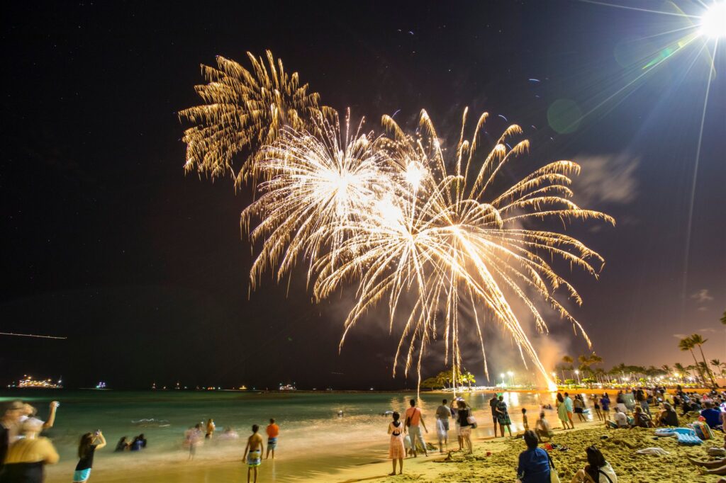 Fireworks bursting over a crowded Myrtle Beach shoreline at night